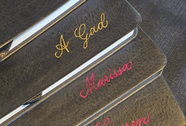 Hot foiling on leather notebooks for a conference done by Handwritten by Belle.