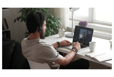 a man sitting at a desk with a laptop computer