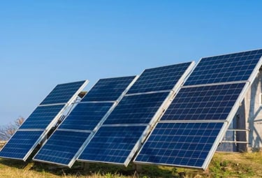 Ground-mounted solar panels harvesting renewable energy under a clear blue sky.