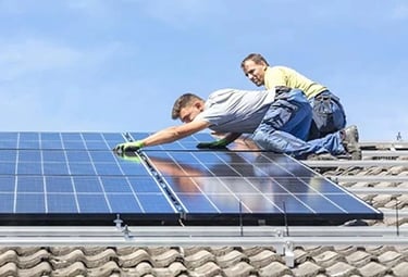 Professional solar panel installation by technicians on a residential tiled roof.