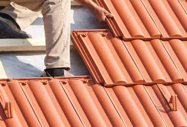 Un couvreur posant des tuiles