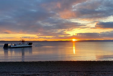 Largs bay at sunset with the ferry to Cumbrae coming in to land