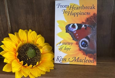 From Heartbreak to Happiness Book on a shelf next to a sunflower