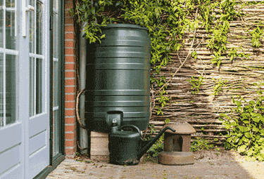 a large black water tank sitting in front of a house
