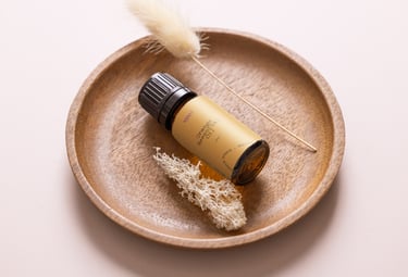 a bottle of essential oils on a plate with a feather feather
