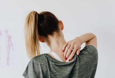 Une femme qui se touche la nuque car elle a une douleur cervicale