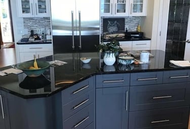 Two-tone kitchen with white shaker cabinets and a dark grey island.