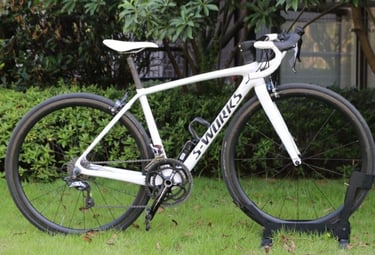 White Specialized S-Works Tarmac carbon fiber road bike parked on a green lawn.