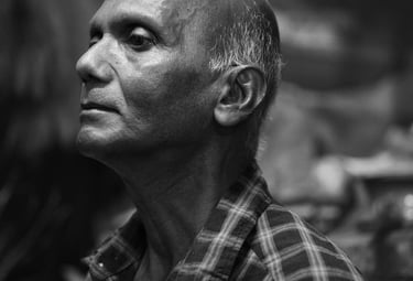 Black and white portrait of an elderly man with a calm expression, wearing a checkered shirt, taken in Mauritius