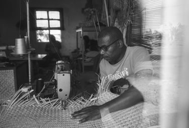 A man in Rodrigues sewing traditional woven material using a machine inside a workshop