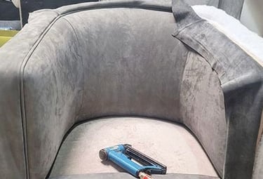 Gray velvet chair mid-reupholstery with tools on seat, showing custom work by Solo Home Decor.