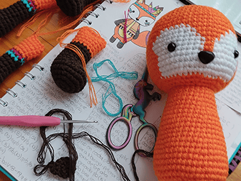 Un amigurumi de un zorrito desarmado, con las piezas listas para ser terminado