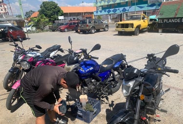 Mecánico realizando mantenimiento a motocicletas Empire Keeway en un estacionamiento al aire libre