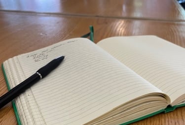 Image of open lined journal with pen on wooden table 