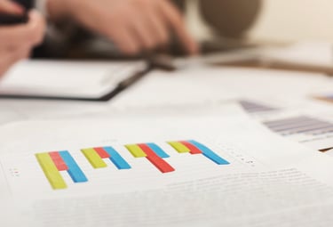 Professional business report showing colorful bar charts during a financial data analysis meeting.