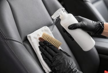 Close-up of a technician polishing a car dashboard with microfiber cloth.