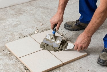Technician carefully mounting a flat-screen TV on a modern living room wall.