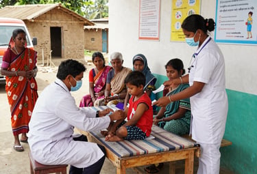 Volunteers distributing medical supplies during a health camp in a village.