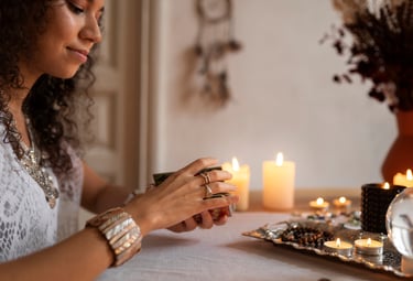 a woman sitting at a table with candles and candles