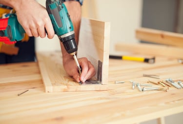 handyman assembling wooden furniture and fixtures in an Auckland workshop