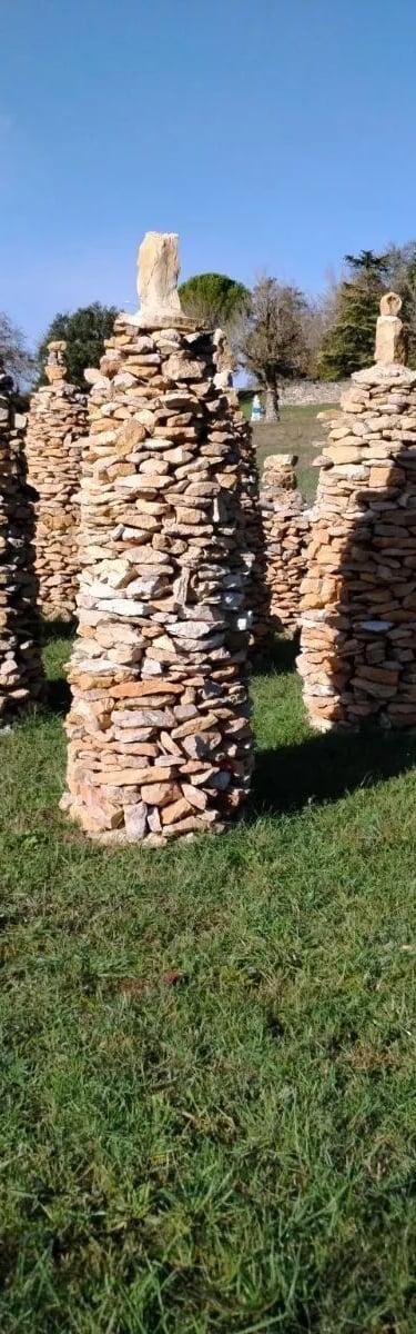 un groupe de sculptures en pierre dans un champ herbeux