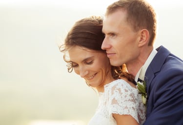 a bride and groom embracing each other in a field