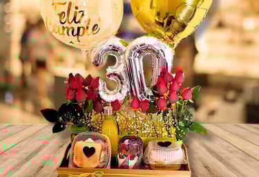 Una caja de madera llena de frutas y flores y un globo en forma de corazón.