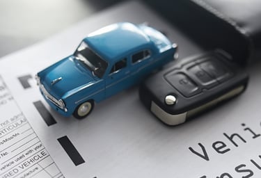 Carro azul de juguete sobre un contrato de compraventa de vehículo usado junto una llave de auto