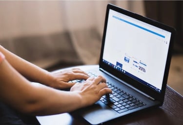 a person is typing on a laptop computer