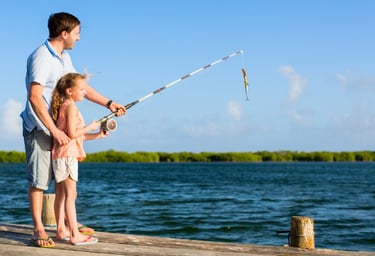 Father And daughter fishing from dock