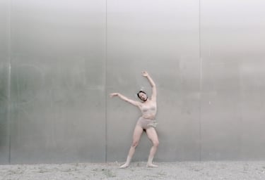  Contemporary dancer with arms extended in minimalist setting – Lingua Materna film still by Tina Bikic