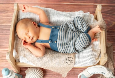 a baby boy sleeping in a crib with a baby bottle of water