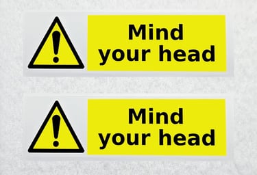 two signs with a warning sign that says mind your head
