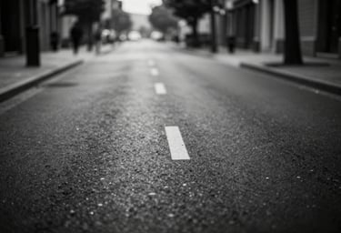 A high-contrast black and white landscape of an empty street, deep #0F0F0F blacks and crisp #F5F5F5 whites, cinematic atmosphere, lonely and artistic.