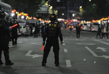 South Korean police officer in tactical gear directing night traffic with glowing batons.