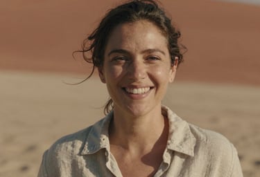 Close-up portrait of a smiling woman in a linen shirt, natural cinematic lighting, warm sand and terracotta background, authentic expression.