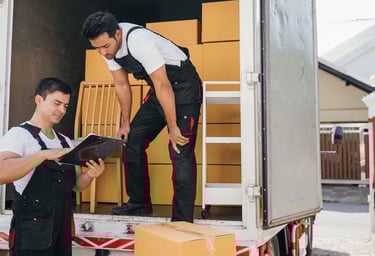 dos trabajadores de mudanza descargando un camión