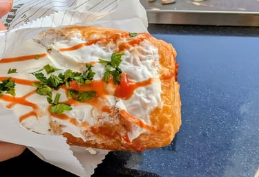 Pizza pastry filled with cured meats, tomaroes sause and cheese and topped with sour cream Belgrade