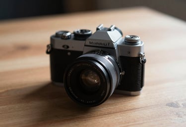 Close-up of a vintage camera on a wooden table. Warm moody lighting with soft Charcoal (#333333) shadows and Soft Sand (#F8F0E3) highlights.