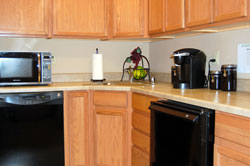 an office kitchen with a microwave, dishwasher, and a microwave