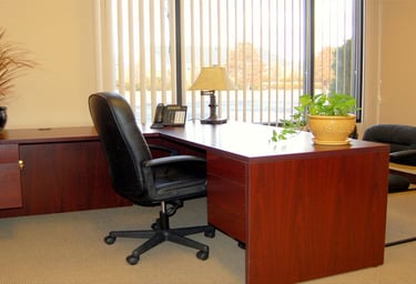 a desk with a chair and a lamp