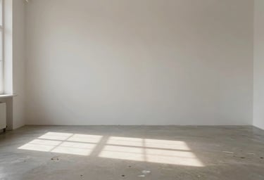Atmospheric shot of an empty studio, sunlight hitting a floor splattered with #6B705C paint, #F9F8F7 walls, peaceful sanctuary vibe.