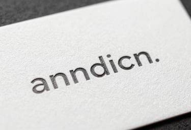 Close-up of a high-quality textured business card with minimalist charcoal typography on a white surface.