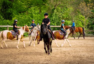 a group of people riding horses in a field