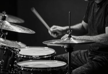 A black and white detail shot of a drummer's hands striking a cymbal. Motion blur adds to the raw energy and emotion. Dark, minimalist aesthetic, captured in a Western European / Dutch studio.