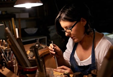 Joyera artesana elaborando joyas hechas a mano con herramientas profesionales en un taller