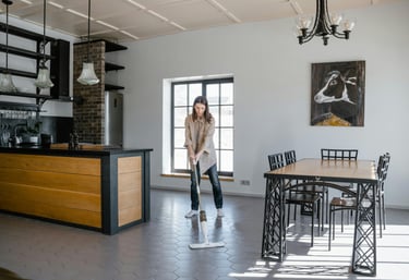 a woman in a kitchen with a mop cleaning the floor