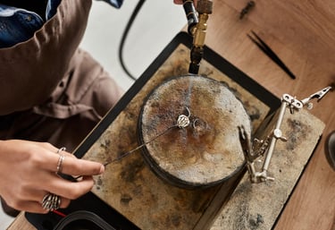 Joyero utilizando un soplete de gas para soldar un anillo de plata