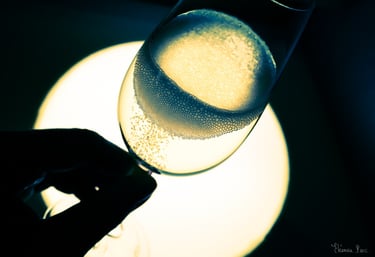 Abstraction Vinicole – Flûte de vin effervescente, couronne de bulles, main en ombre