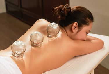Une femme sur une table de soins se fait poser des ventouses, ou de la cupping thérapie